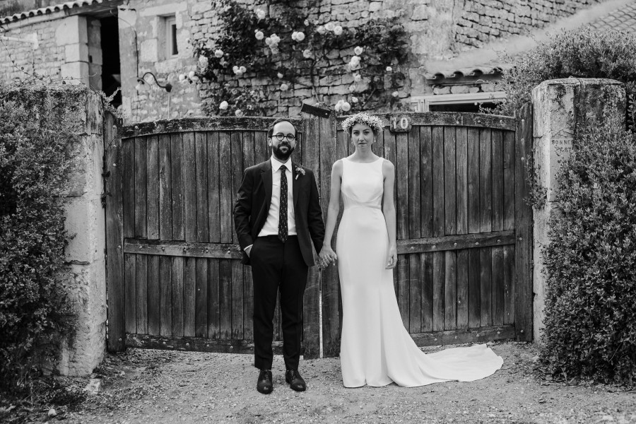 couple mariés portail maison pierre noir et blanc